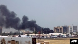 Tymi duke dalë nga ndërtesat afër Aeroportit të Kartumit. 15 prill 2023.