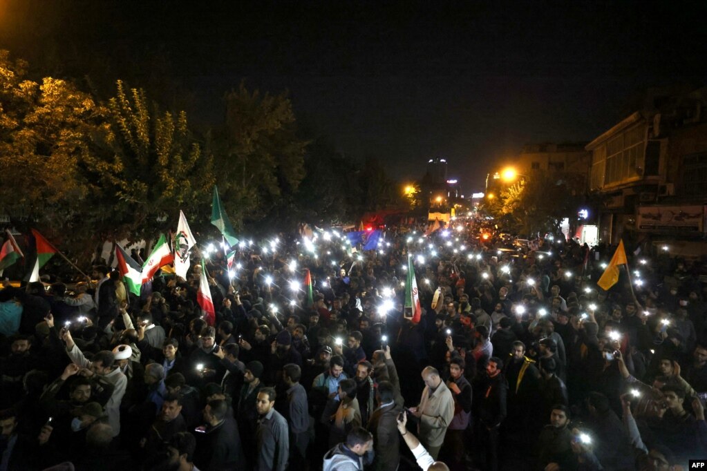 Studentë dhe protestues në Teheran ndezin dritat e telefonëve teksa protestojnë para Ambasadës britanike në Teheran, mëngjesine  hershëm të 18 tetorit 2023. 