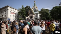 A crowd gathers ton protest outside a Russian Orthodox church in Sofia on September 24. 