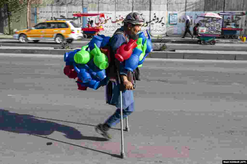 Afganistanac nosi plastične ibrike dok traži mušterije duž ceste u Kabulu, 26. oktobra.