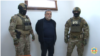 Former Karabakh premier Ruben Vardanyan flanked by Azerbaijani security officers appears before an interrogator after his arrest and transfer to Baku in late September 2023.