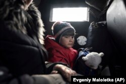 O fetiță și mama sa sunt evacuate din Avdiivka, în regiunea Donețk. 7 martie 2023.
