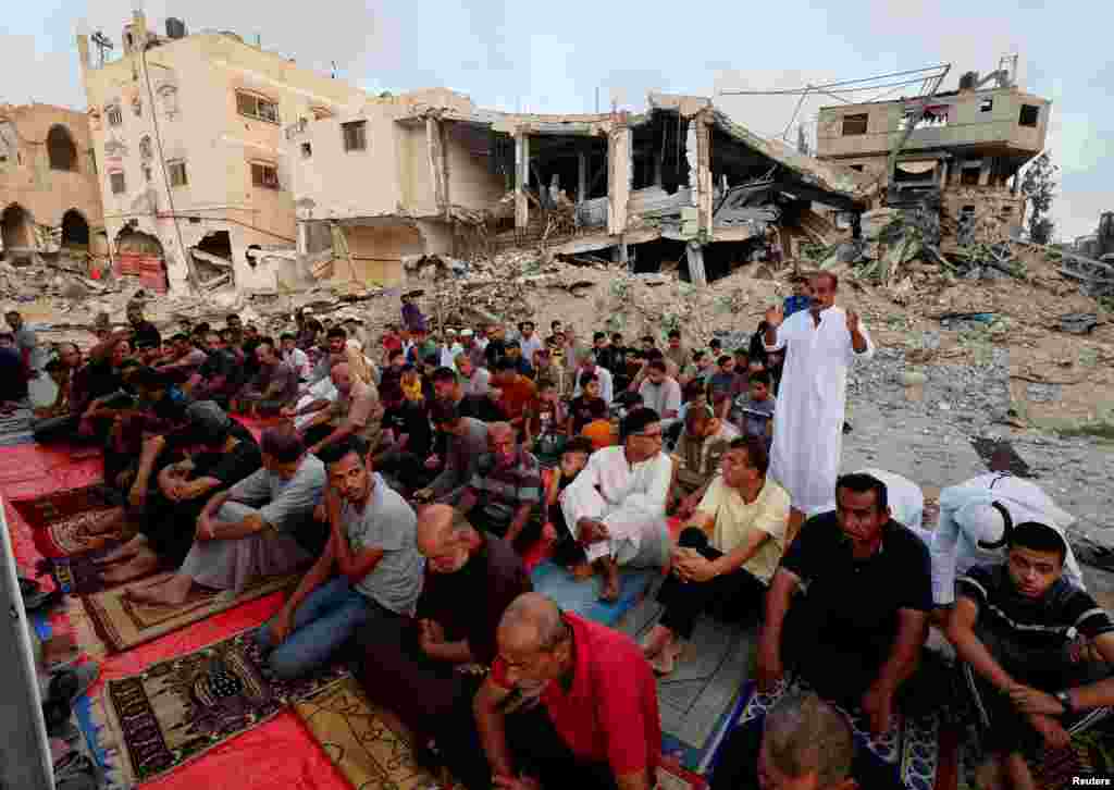 Palestinezët e falin Kurban Bajramin në rrënojat e xhamisë Al-Rahma, e cila u shkatërruar nga sulmet ajrore izraelite, gjatë konfliktit mes Hamasit dhe Izraelit, në Kan Jounis, Gazë, 16 qershor 2024.