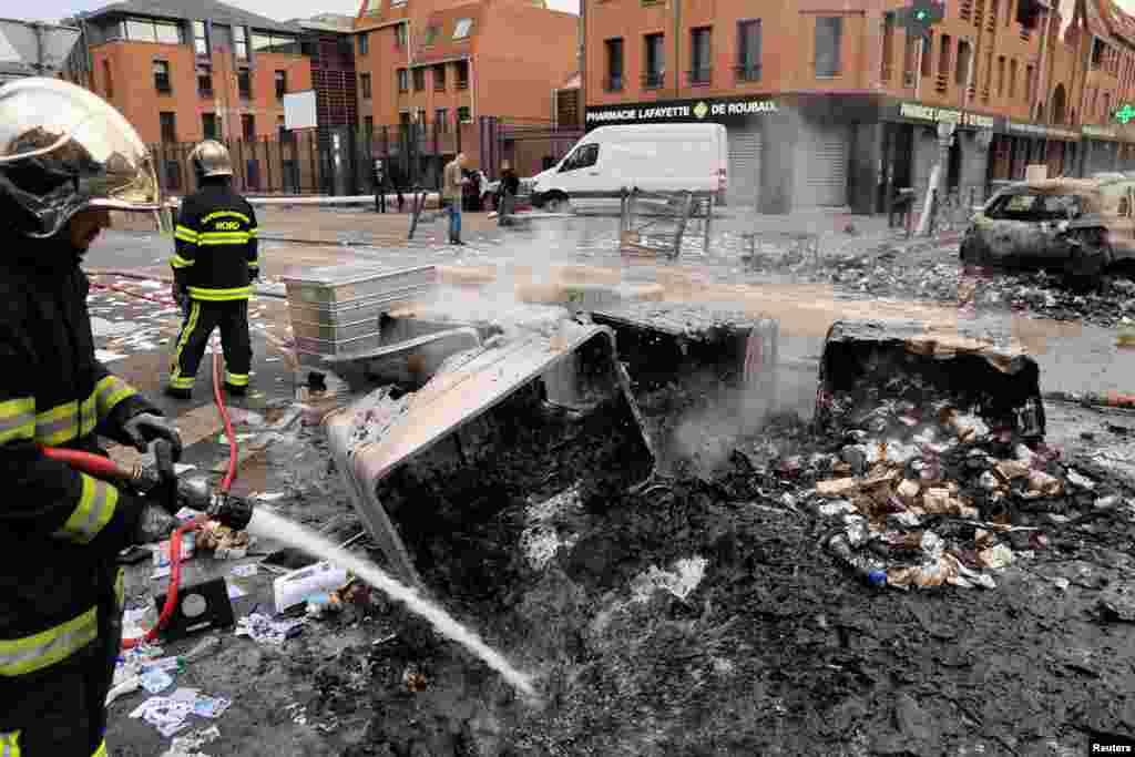 Vatrogasci gase vatru na objektima koji su izgorjeli tokom noćnih sukoba između demonstranata i policije, u četvrti Alma u Roubaixu, u sjevernoj Francuskoj , 30. juna 2023.&nbsp;