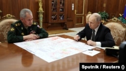 Rusiya prezidenti Vladimir Putin Moskvada görüşü zamanı müdafiə naziri Sergey Şoyqunu dinləyir.