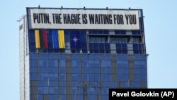بنری با متن «پوتین، لاهه منتظر توست» بر روی ساختمانی در پایتخت لیتوانی در جریان نشست ناتو، ۱۱ ژوئیه ۲۰۲۳