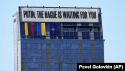 Баннер "Путин, Гаага ждет тебя" на здании в центре Вильнюса во время саммита НАТО, 11 июля 2023 года