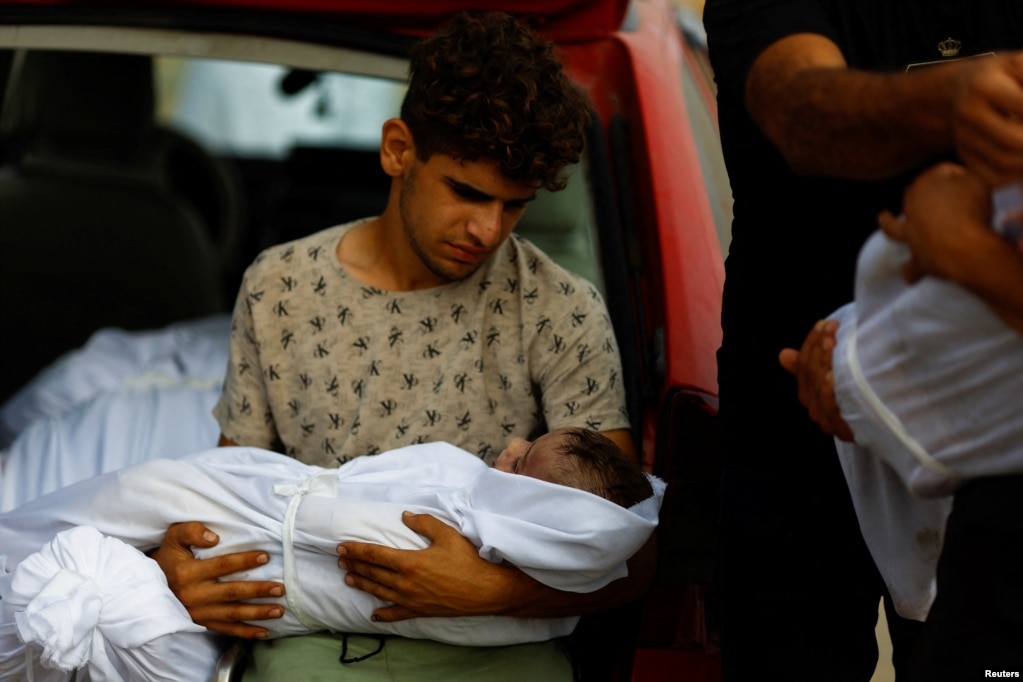 Një djalë mban trupin e një fëmije palestinez të vrarë në sulmet izraelite, Han Junis, Rripi jugor i Gazës, 23 tetor 2023.