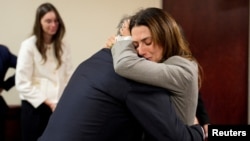  Болдуин прегръща жена си Хилария и други свои близки след завършека на делото. 