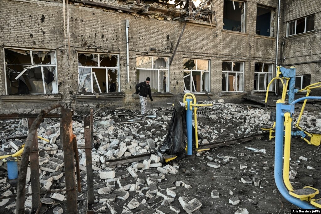 Një burrë duke ecur jashtë një shkolle të shkatërruar pas sulmeve ruse me raketa në Kramatorsk të Ukrainës.