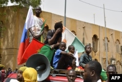 Подростки с флагами Нигера, Буркина-Фасо и России во время многотысячной демонстрации за немедленный вывод солдат армии США, дислоцированных на севере Нигера, после того как хунта заявила, что выходит из соглашения о сотрудничестве с Вашингтоном от 2012 года. 13 апреля 2024 года