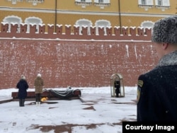 Жены мобилизованных в белых платках возлагают цветы у Кремлевской стены