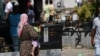 Një grua mban në dorë një fëmijë teksa lyp para në rrugët e Prizrenit, Kosovë.