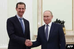 Russia's President Vladimir Putin (right) shakes hands with Syria's President Bashar al-Assad during a meeting at the Kremlin in Moscow on July 24.