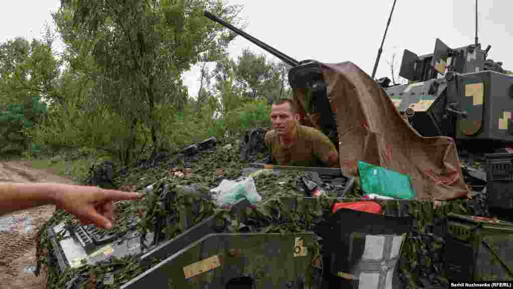 A tanker inside a M2 Bradley receives direction from a Ukrainian soldier. Ukraine has made advances on the southern and eastern parts of the front line, but Russia is fighting back, destroying Western-supplied weaponry. &nbsp;