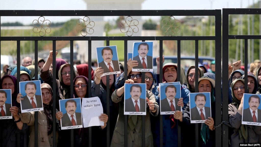 اعضای سازمان مجاهدین خلق در اردوگاه اشرف ۳ در آلبانی عکس فردی که گفته میشود در درگیری با پلیس این کشور کشته شده است را در دست گرفتهاند