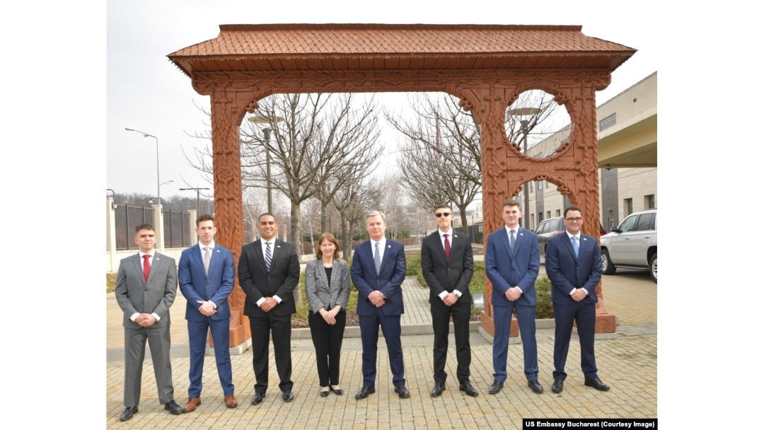 Ambasadorul Kathleen Kavalec împreună cu directorul FBI, Christopher Wray, și infanteriștii marini ai Ambasadei SUA la București în fața porții maramureșene de la Ambasada SUA, 21 februarie.