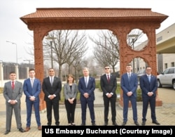 Ambasadorul Kathleen Kavalec împreună cu directorul FBI, Christopher Wray, și infanteriștii marini ai Ambasadei SUA la București în fața porții maramureșene de la Ambasada SUA, 21 februarie.