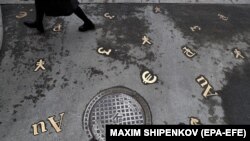 Simboluri valutare pe trotuarul din fața unei bănci, la Moscova