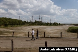 United Nations officials look at the dried bottom of the Kakhovka water reservoir.