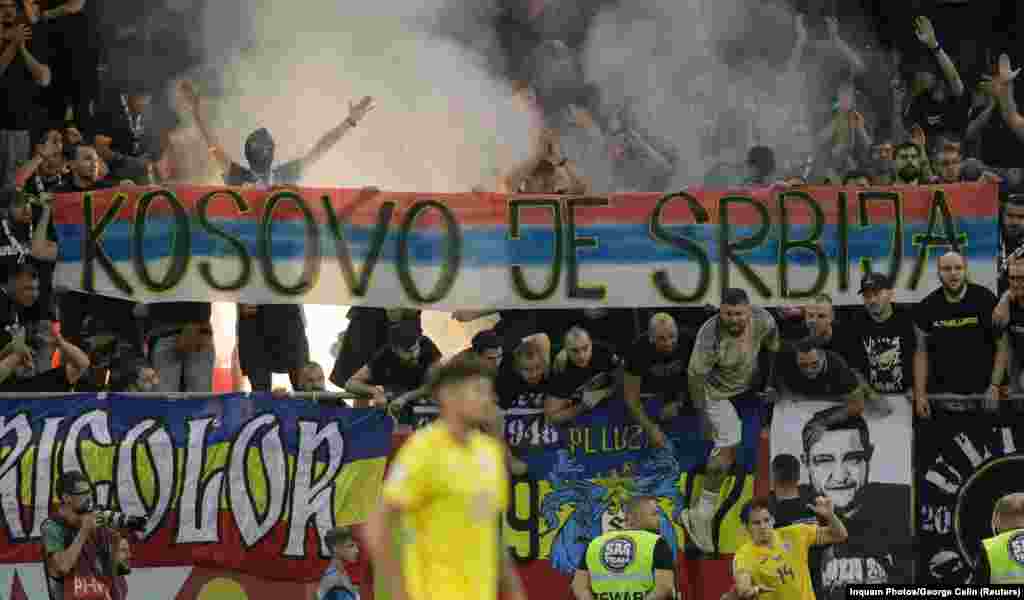 Romanian football fans hold up banners that subsequently suspended play temporarily during a Euro 2024 qualifier match between Romania and Kosovo at National Arena in Bucharest on September 12. A section of Romanian fans held up a banner that read &quot;Kosovo is Serbia,&quot; while some members of the home end chanted &ldquo;Serbia, Serbia,&rdquo; according to Reuters.