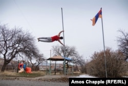 Hamo Hloian demonstrates a "human flag" outside the "House of Titans" during a training evening.