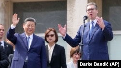 Xi Jinping (stânga) salută publicul în timp ce președintele sârb Aleksandr Vucic vorbește la Palatul Serbiei din Belgrad, 8 mai 2024.