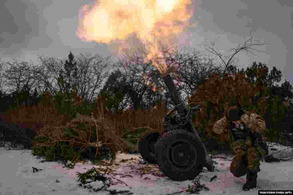 A Ukrainian serviceman of the 93rd brigade covers his ears while firing a French 120mm rifled towed mortar toward Russian positions in Bakhmut.