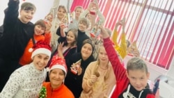 Oksana și Mila cu o parte dintre copiii care se strâng în fiecare săptămână la Casa de Cultură de la Ploiești. 