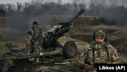 Ushtarët ukrainas qëllojnë një obus në drejtim të pozicioneve ruse pranë Bahmutit, rajoni i Donetskut. 7 mars 2023.
