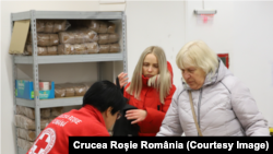 Refugiați ucraineni primesc ajutoare alimentare din partea Crucii Roșii România.