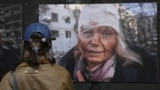 A woman looks at a photograph by Wolfgang Schwan of Ukrainian teacher Olena Kurilo, who was injured on February 24, 2022 -- the first day of the Russian invasion --  at the Ukraine: A War Crime exhibition, which opened in Pristina on April 29.