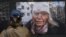 A woman looks at a photograph by Wolfgang Schwan of Ukrainian teacher Olena Kurilo, who was injured on February 24, 2022 -- the first day of the Russian invasion --  at the Ukraine: A War Crime exhibition, which opened in Pristina on April 29.