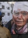 Žena gleda jednu od fotografija izložbe "Ukrajina: ratni zločin" koja je otvorena u Prištini 29. aprila 2024.