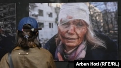 Žena gleda jednu od fotografija izložbe "Ukrajina: ratni zločin" koja je otvorena u Prištini 29. aprila 2024.
