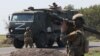 Russian soldiers guard a road as a Russian military convoy in Zaporizhzhya, Ukraine. 