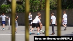 Деца играят футбол в двора на 22. СЕУ „Георги Раковски“ в София.