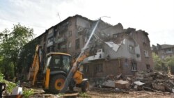 Oamenii din Harkov curăță molozul după un nou bombardament rusesc