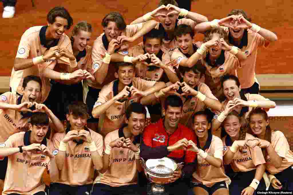 Serbia&#39;s Novak Djokovic celebrates with the trophy and ball kids after winning the French Open on June 11.
