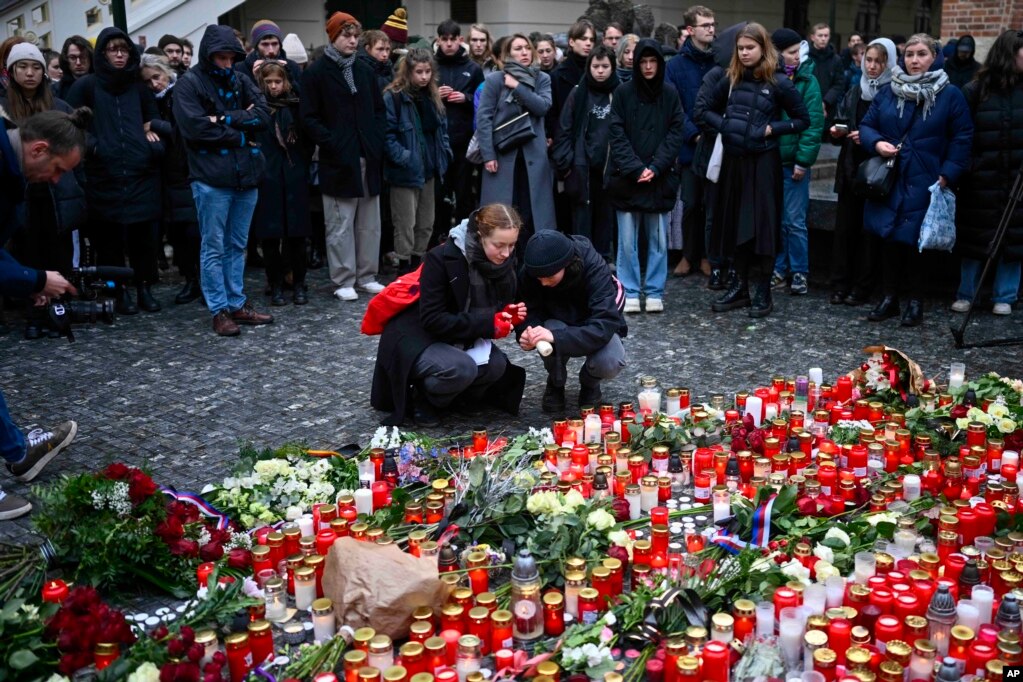 Njerëzit vendosin lule dhe qirinj jashtë selisë së Universitetit Charles, në shenjë nderimi për viktimat nga të shtënat masive në Pragë, Republika Çeke, të premten, 22 dhjetor 2023. Një person i armatosur i vetëm hapi zjarr në një universitet të enjten, duke vrarë së paku 13 persona dhe duke plagosur shumë të tjerë.