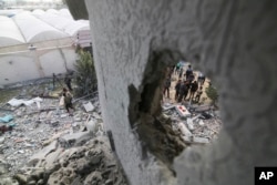  Палестинци преглеждат къща, разрушена при израелски въздушен удар, в Рафах, петък, 22 март 2024 година 