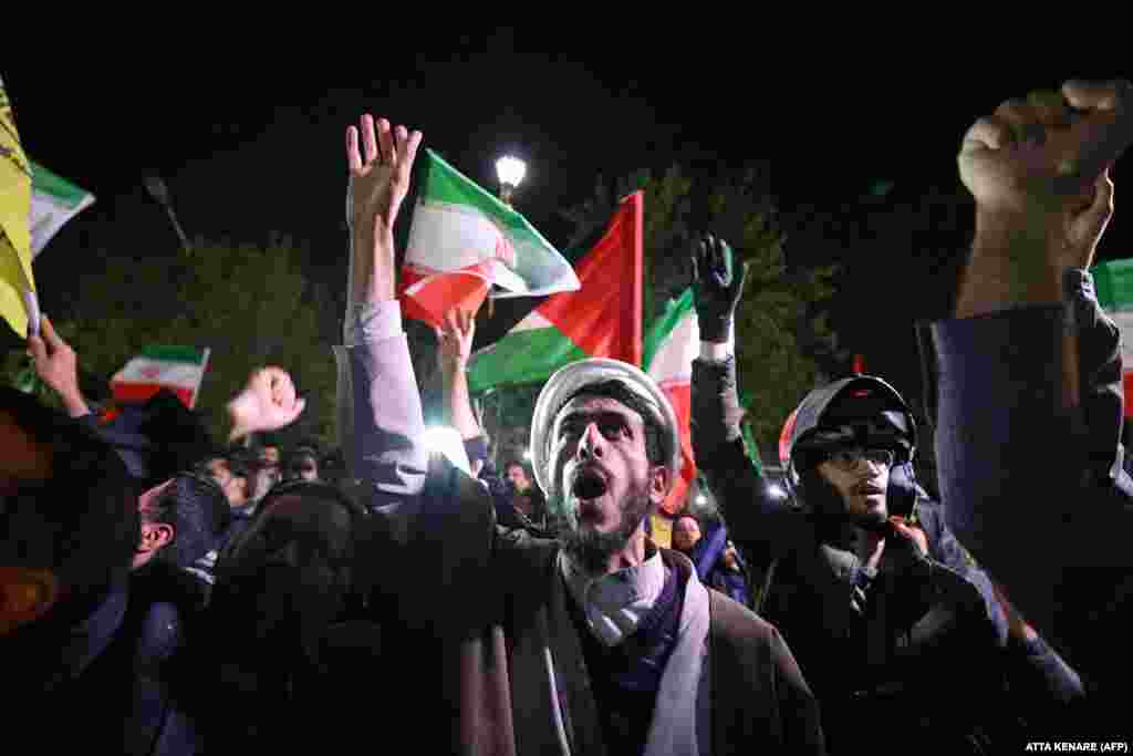 Prosvjednici mašu iranskim i palestinskim zastavama ispred britanskog veleposlanstva u Teheranu u znak potpore napadu iranskih dronova i projektila na Izrael, 14. aprila.