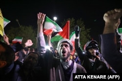 Демонстранти з іранськими та палестинськими прапорами біля посольства Британії в Тегерані після запуску сотень іранських ракет та дронів проти Ізраїлю. Тегеран, 14 квітня 2024 року