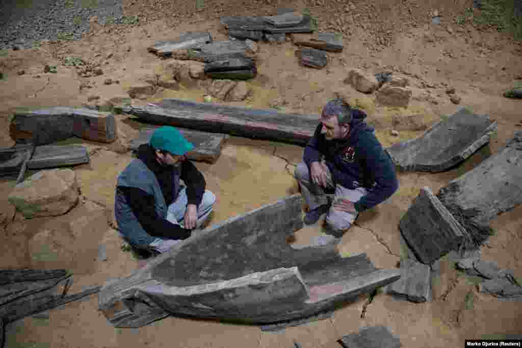 In this photo from May 2020, archaeologists inspect parts of an earlier wooden Roman ship that was discovered near the ancient city. Archaeologists believe that the two ships and three canoes uncovered so far in the area either sank or were abandoned at the riverbank.