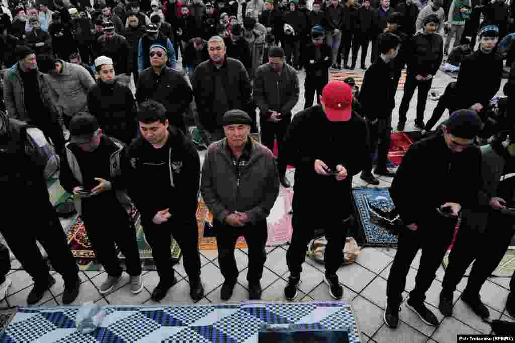 Мусульмане молятся у входа в Центральную мечеть Алматы. К началу утренней молитвы свободных мест не осталось даже на ближайших тротуарах