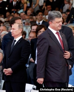 Fostul președinte ucrainean, Petro Poroșenko (dreapta), trece pe lângă președintele rus, Vladimir Putin, în timpul celei de-a 70-a aniversări a Zilei Z, pe 6 iunie 2014 în Ouistreham, Franța.