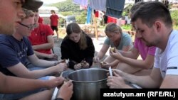 Young people from the Netherlands cook their meal together in the village of Vahagni, Lori Province, Armenia, where they are spending their summer vacation volunteering. 