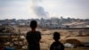 Dečaci posmatraju dim koji se diže tokom izraelskih napada istočno od Rafaha u južnom pojasu Gaze 13. maja 2024. 