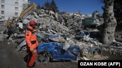 Një burrë i ekpiës së shpëtimit qëndron përpara rrënojave pranë vendit ku Aleyna Olmez, 17-vjeçare, u shpëtua nga një ndërtesë e shembur, 248 orë pas tërmetit që goditi pjesë të Turqisë dhe Sirisë, në Kahramanmaras, më 16 shkurt 2023.