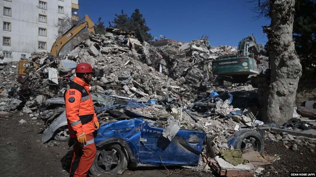 Un salvator privește cum un utilaj sparge bucățile mari de moloz, după cutremurul cu magnitudinea de 7,8 care a lovit Turcia și Siria. Kahramanmaras, 16 februarie 2023.